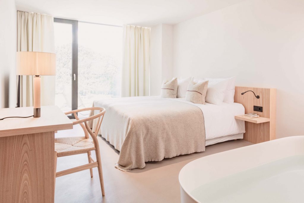 Hauptschlafzimmer der Familiensuite mit Schreibtisch, freistehender Badewanne und Bergblick