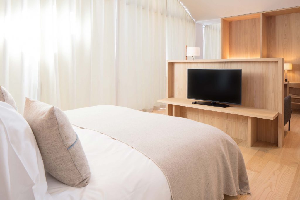 Zimmeransicht der Town Suite im Boutique Hotel Schgaguler - Bett mit Handgemachten Decken aus Merino Wolle.